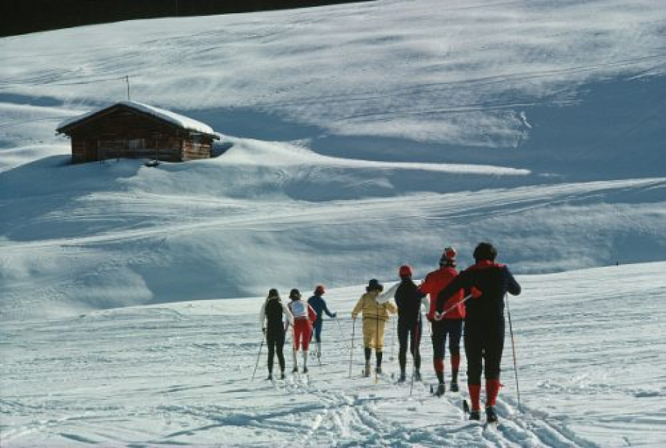 Slim Aarons. 'Ski Hike'. Skiers line up for a hike to ski resort Zurs from Lech, Austria, February 1979